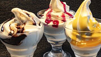 Three dessert cups with whipped cream and toppings.