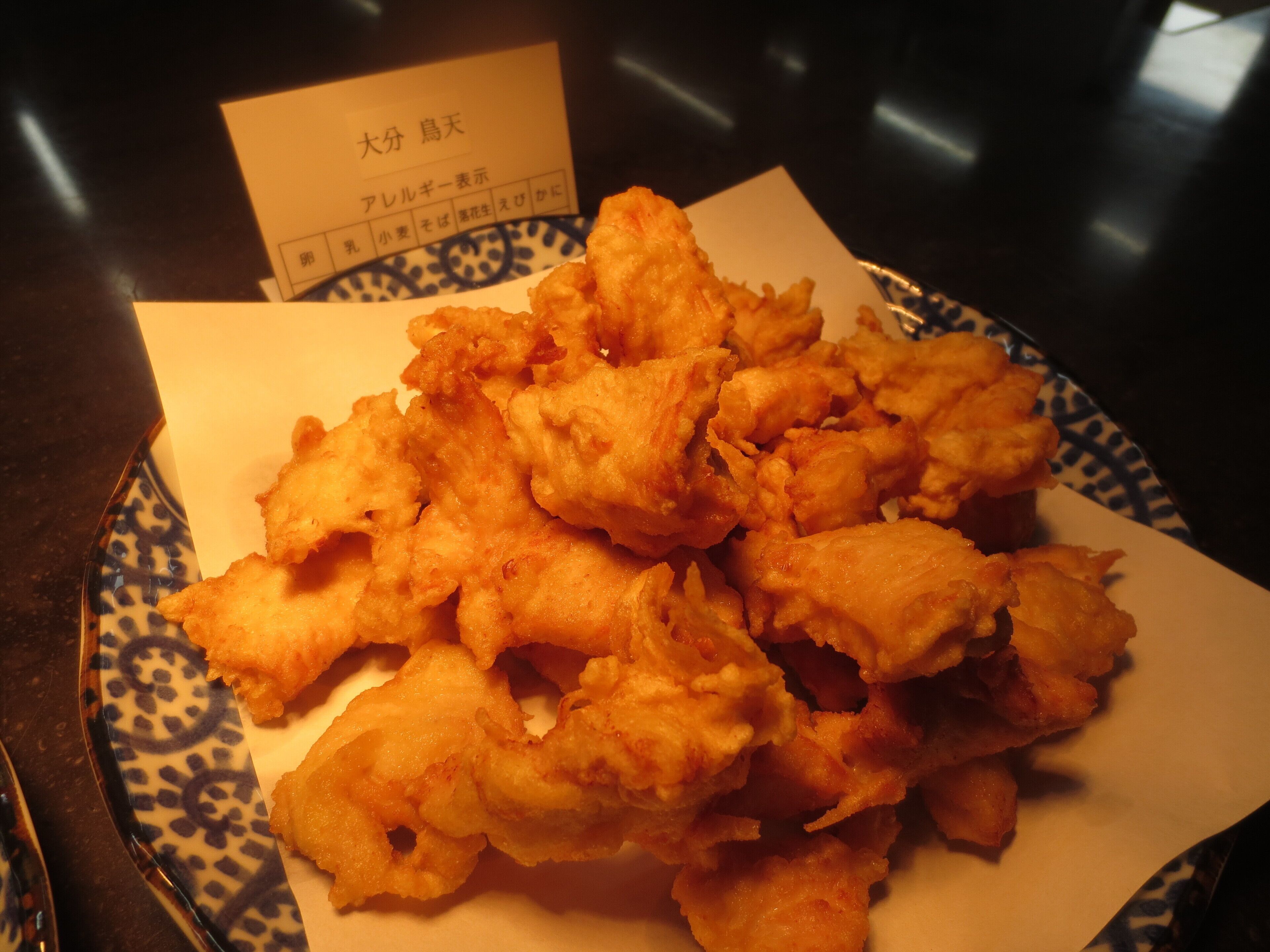 A plate of fried food with a paper menu in the background.