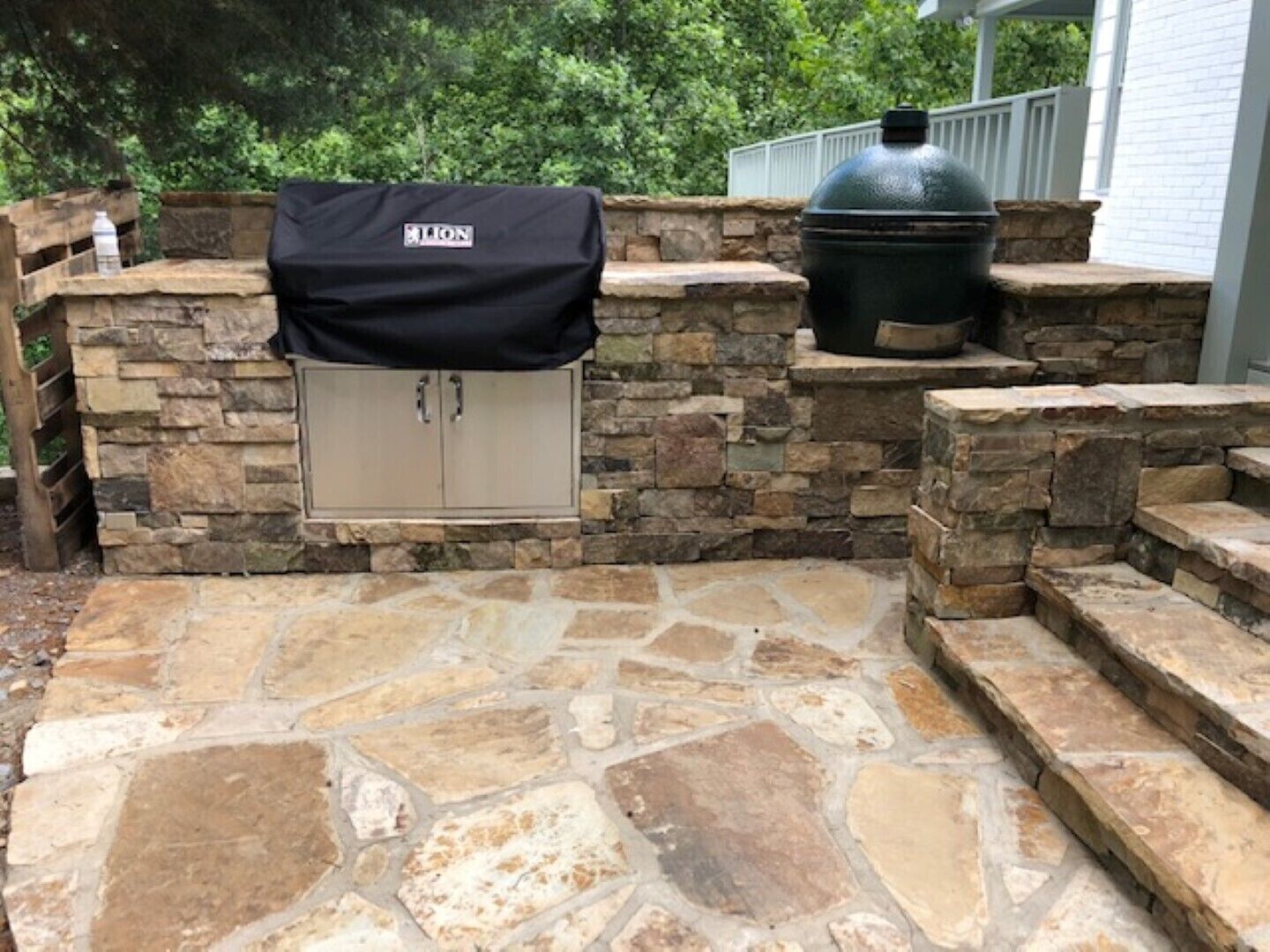 A stone patio with a grill cover and a large pot.