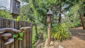 Una cerca de madera con un comedero para pájaros y una casa para pájaros.