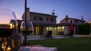 A stone house with a patio, outdoor seating, and a glass of wine. - VILLA SALVIA**** Rakalj  (Rakalj)