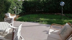 An outdoor patio with a covered seating area, a lawn, and a hedge. - PROMOZIONE-Appartamento ristrutturato a 30 mt dal mare (Follonica)