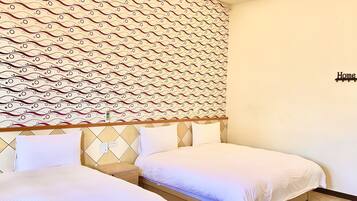 Quarto de hotel com duas camas, papel de parede estampado e um letreiro com a palavra 'Home'.