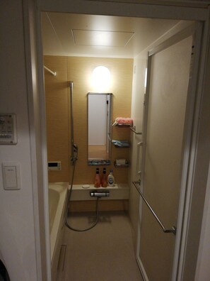 A compact bathroom with a shower, a mirror, and a sink. - Jay and Lan's Himawari house (Tokyo)