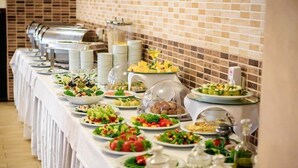 A buffet setup with various food items and condiments. - Menorah Hotel (Dnipro)