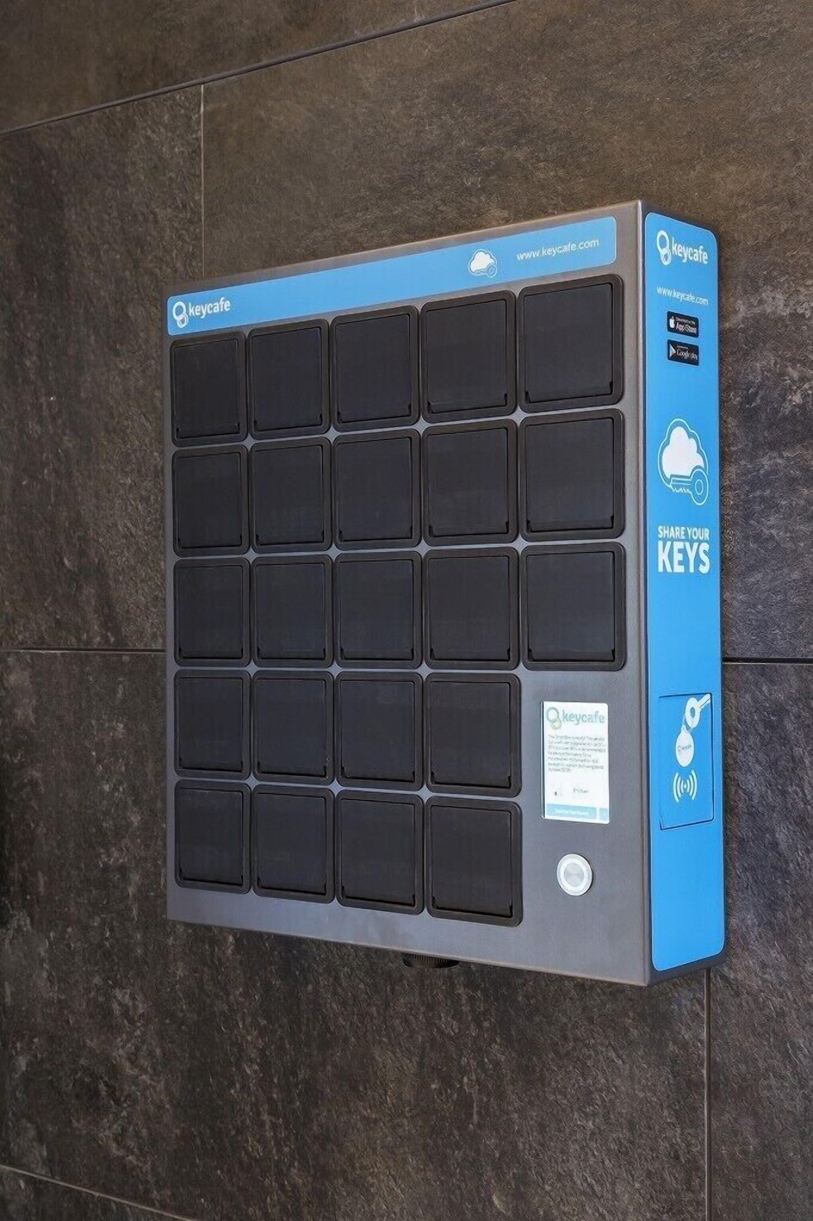 Un dispositivo fijado a la pared con varios compartimentos para llaves, una dirección web y un código QR.