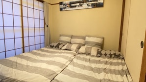 A traditional Japanese-style room with tatami flooring, a futon bed, shoji screens, and a hanging light fixture. - Shibuya Japanese-style room 2DK small up to family 4 parsons + Pocket Wifi (渋谷区)
