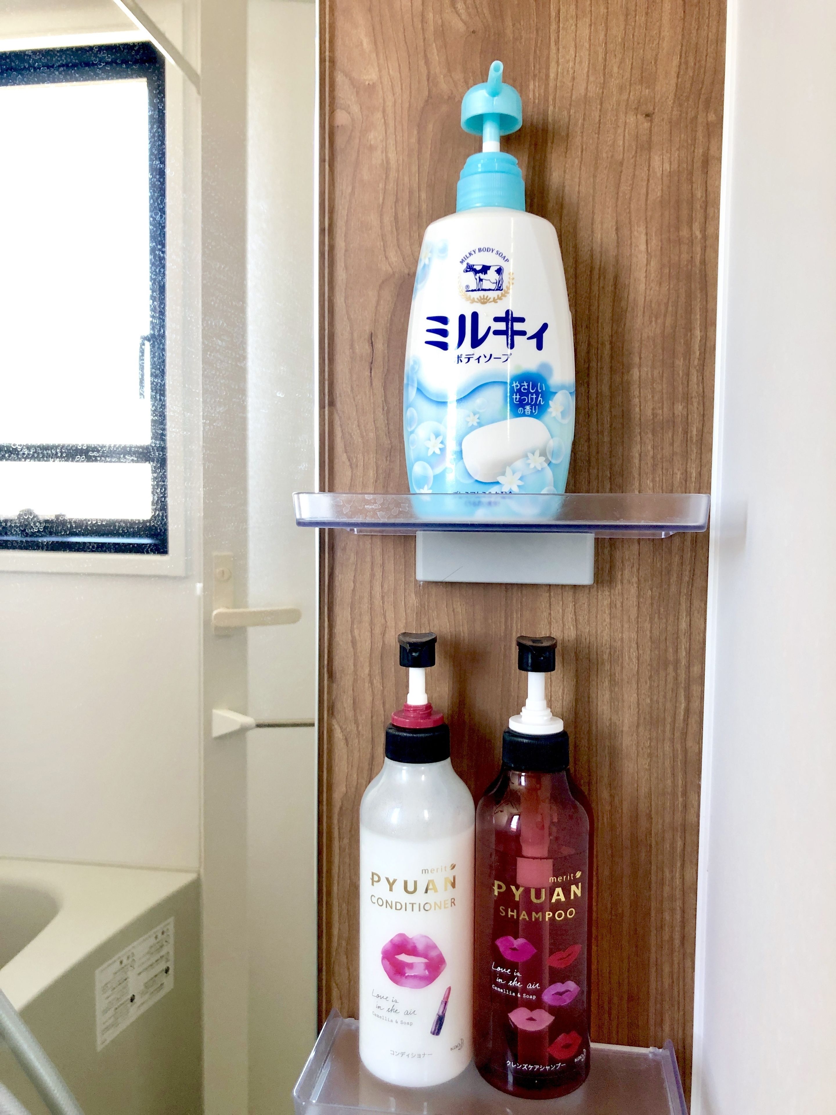 Ein Badezimmerschrank mit Toilettenartikeln, darunter Duschgel, Spülung und Shampoo.