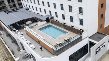 Una piscina al aire libre, sombrillas, tumbonas