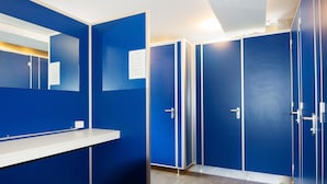 Una hilera de taquillos azules con puertas blancas y un mostrador blanco.