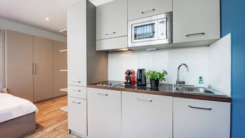 A modern kitchen with a microwave, coffee maker, and sink.