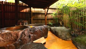 Un jardín de rocas con un banco de madera y un pequeño estanque.