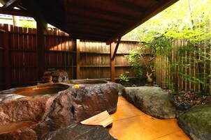 A rock garden with a wooden bench and a small pond.