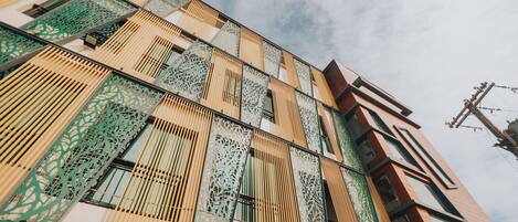 A modern building with a unique facade featuring geometric patterns and vertical slats.