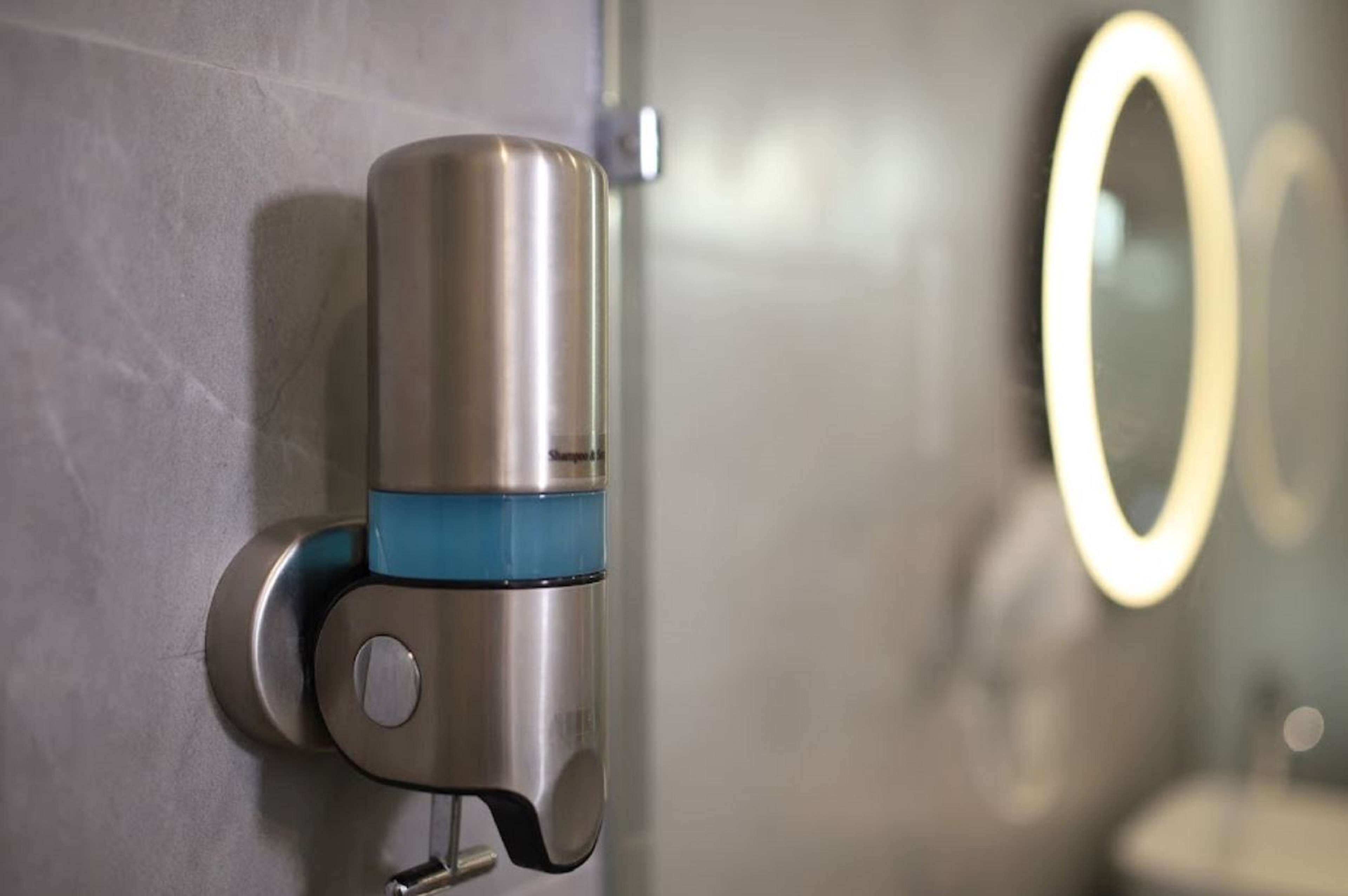 A metallic object attached to a wall, possibly a sensor or device, with a circular light feature nearby.