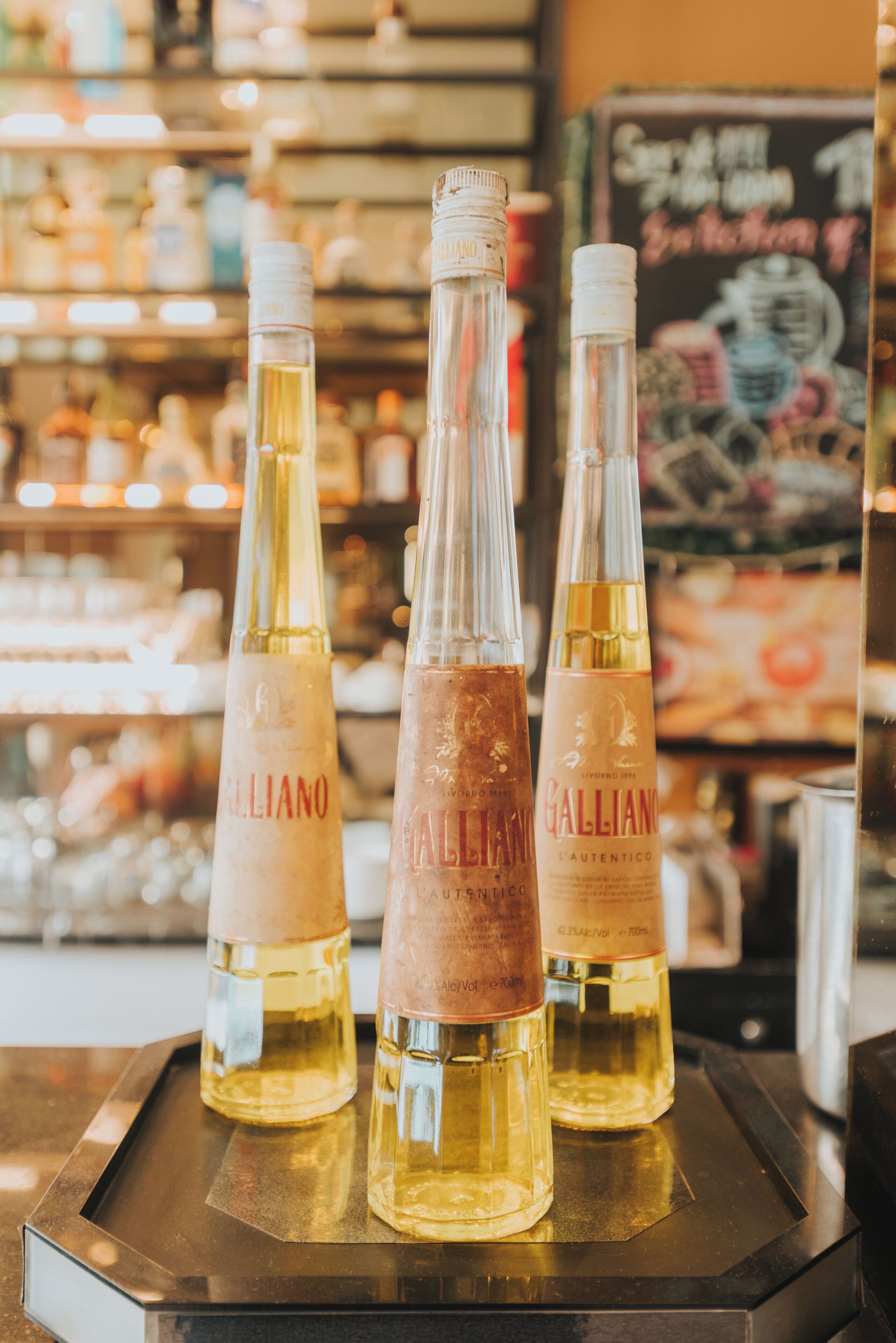 Three bottles of Galliano on a tray.