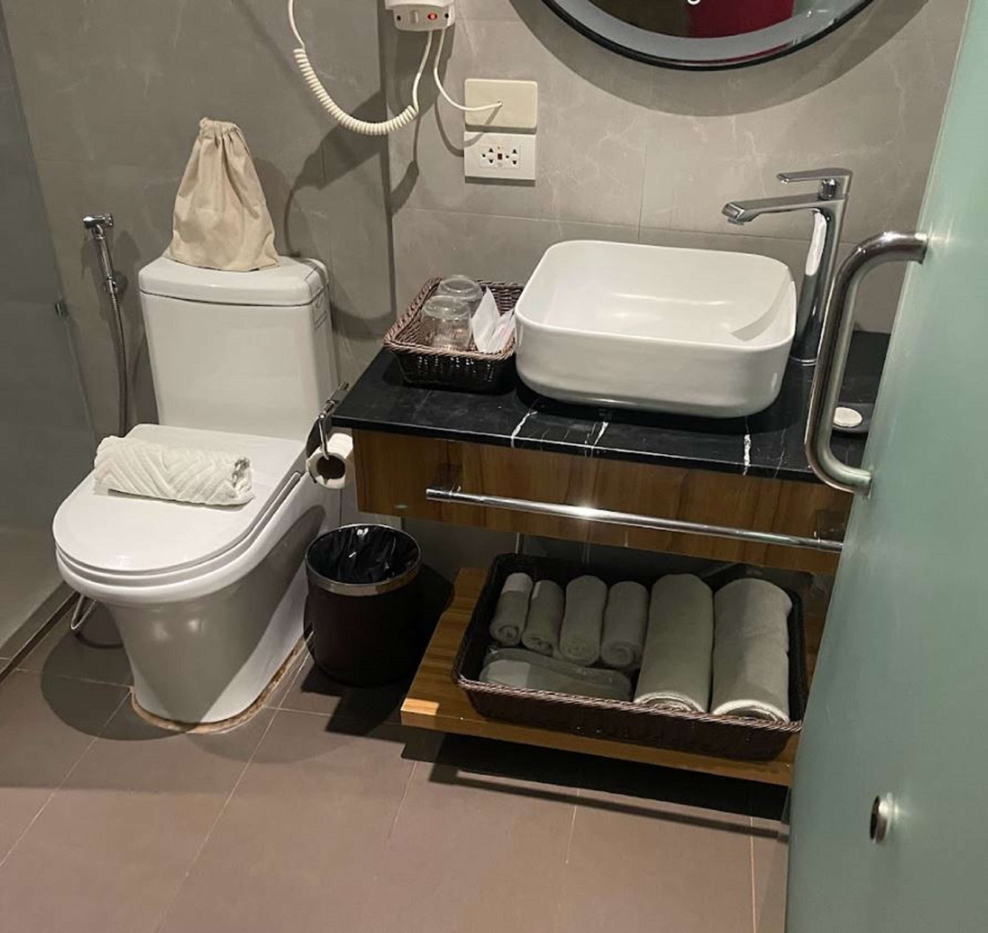 A modern bathroom with a toilet, sink, and towel rack.