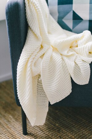 A chair with a white knitted blanket draped over it. - Bättre Boende (Hässelby)