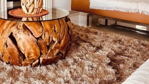 Una sala de estar moderna con una mesa de centro de vidrio, un sofá y una chimenea.