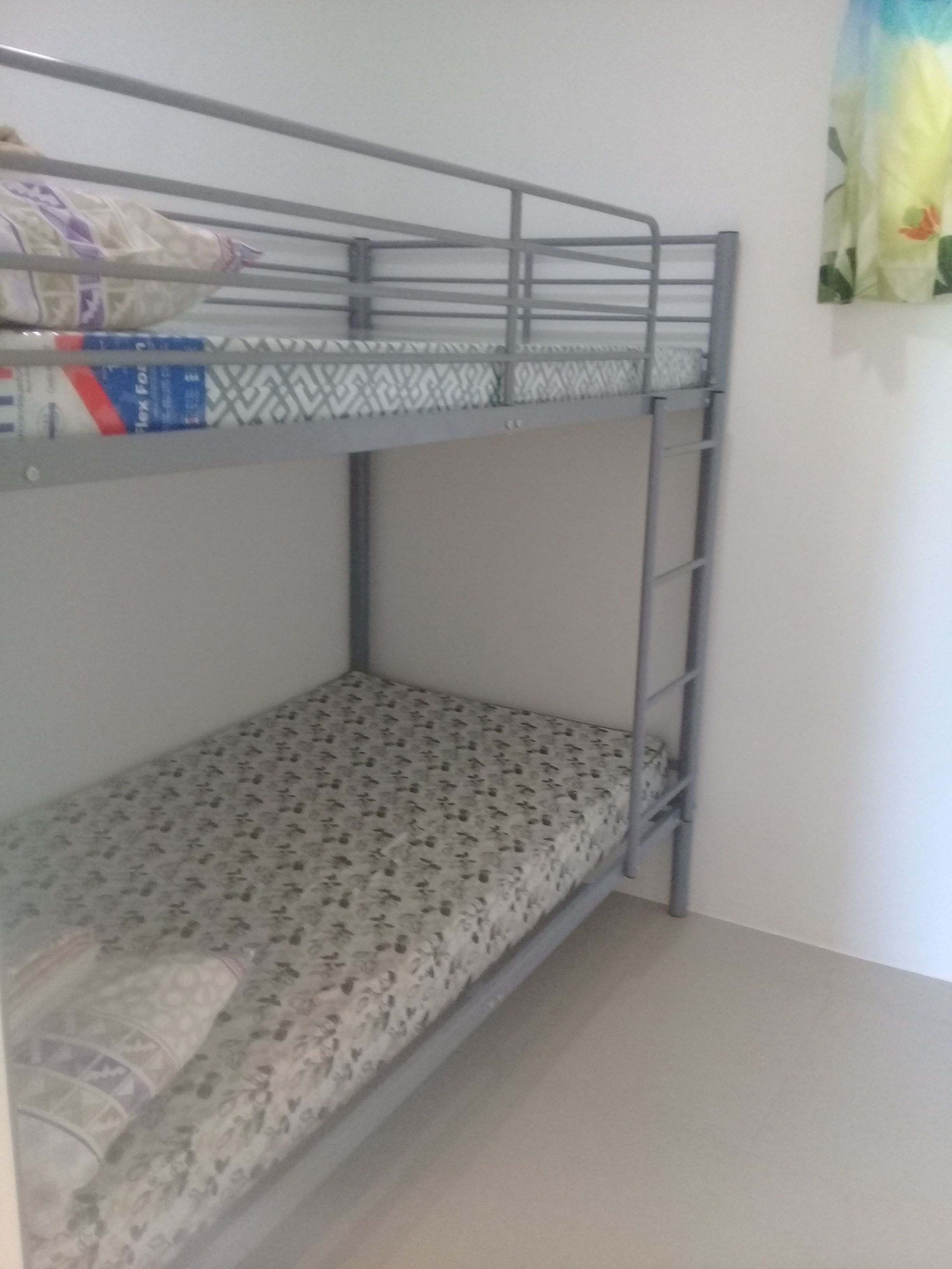 A bunk bed with a patterned mattress and a metal frame.