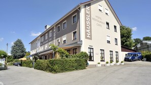 A two-story building with the name "HAUSSLER HOTEL RESTAURANT CAFE" on the facade. - Hotel Häußler (Reichertshofen)