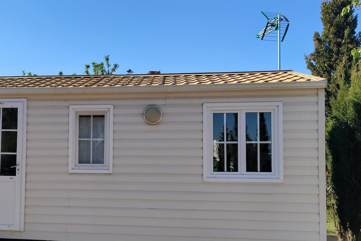 A small, single-story building with a tiled roof, three windows, and a door.