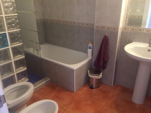 Un baño con bañera, inodoro y lavabo.