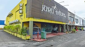 A building with a sign that reads 'Juru Hotel.' There is a motorcycle parked outside. - Juru Hotel (Simpang Ampat)