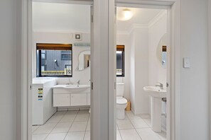 Ein modernes Badezimmer mit großem Fenster, Waschbecken und Toilette.