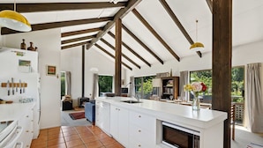 Una cocina amplia con una isla grande, vigas de madera y vistas al exterior.