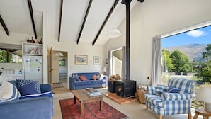 Una sala de estar con sofá, sillón y chimenea.