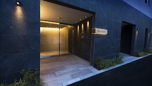 A modern building entrance with a glass door, a sign reading "PHILIPPE," and a small step leading up to the door. - A6 Haneda Maison Philippe Omori 601 (Tokyo)