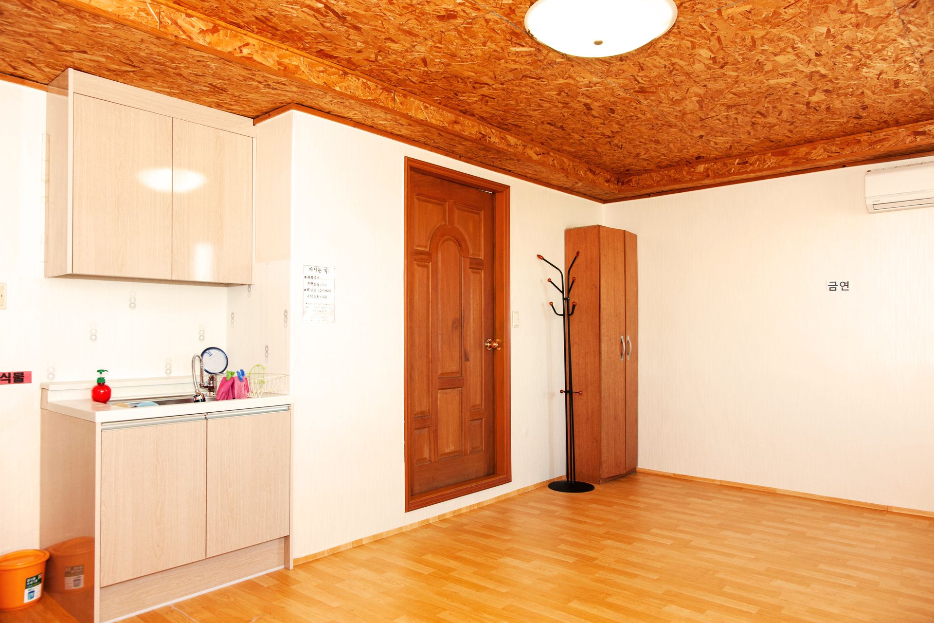 A kitchen with wooden cabinets, a sink, and a wooden floor.