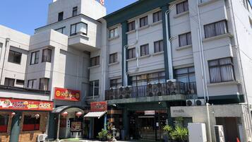 A multi-story building with a restaurant on the ground floor, featuring a traditional Asian architectural style with a tiled roof and a signboard.