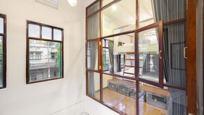 A hotel room with a large sliding glass door, a small window, and a view of the outside. - REST IS MORE Hostel (Bangkok)