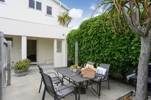 Enjoy dining or socializing in this patio area with a table and chairs.