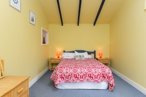 Cozy retreat with a centered bed, nightstands, and framed artwork.