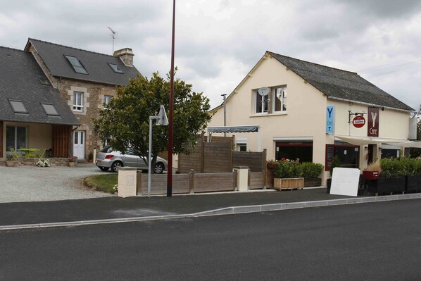 A building with a cafe sign, a parked car, and a signboard with text. - Rental house Argoat in SAINT MICHEL DE PLELAN (St Michel de Plélan)