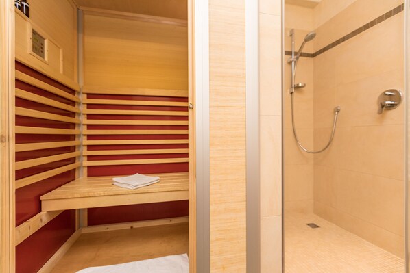 Un vestidor con estantes de madera y zona de ducha.