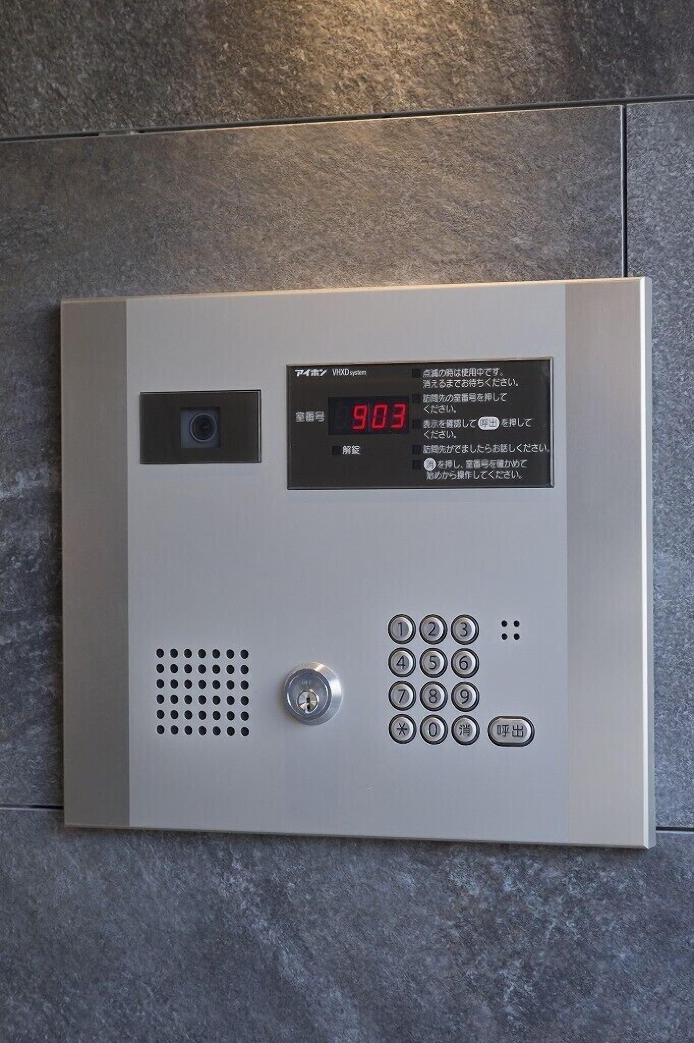 A digital intercom system with a keypad and a display screen.