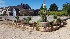 A building with a tiled roof, a flag, and a gravel driveway.