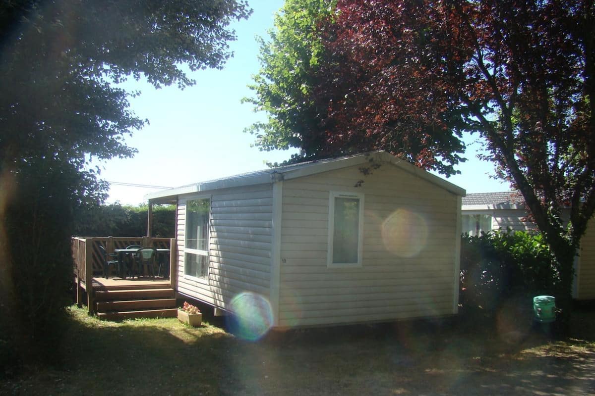 Ein kleines, eingeschossiges Haus mit einer Veranda und einer Garage.