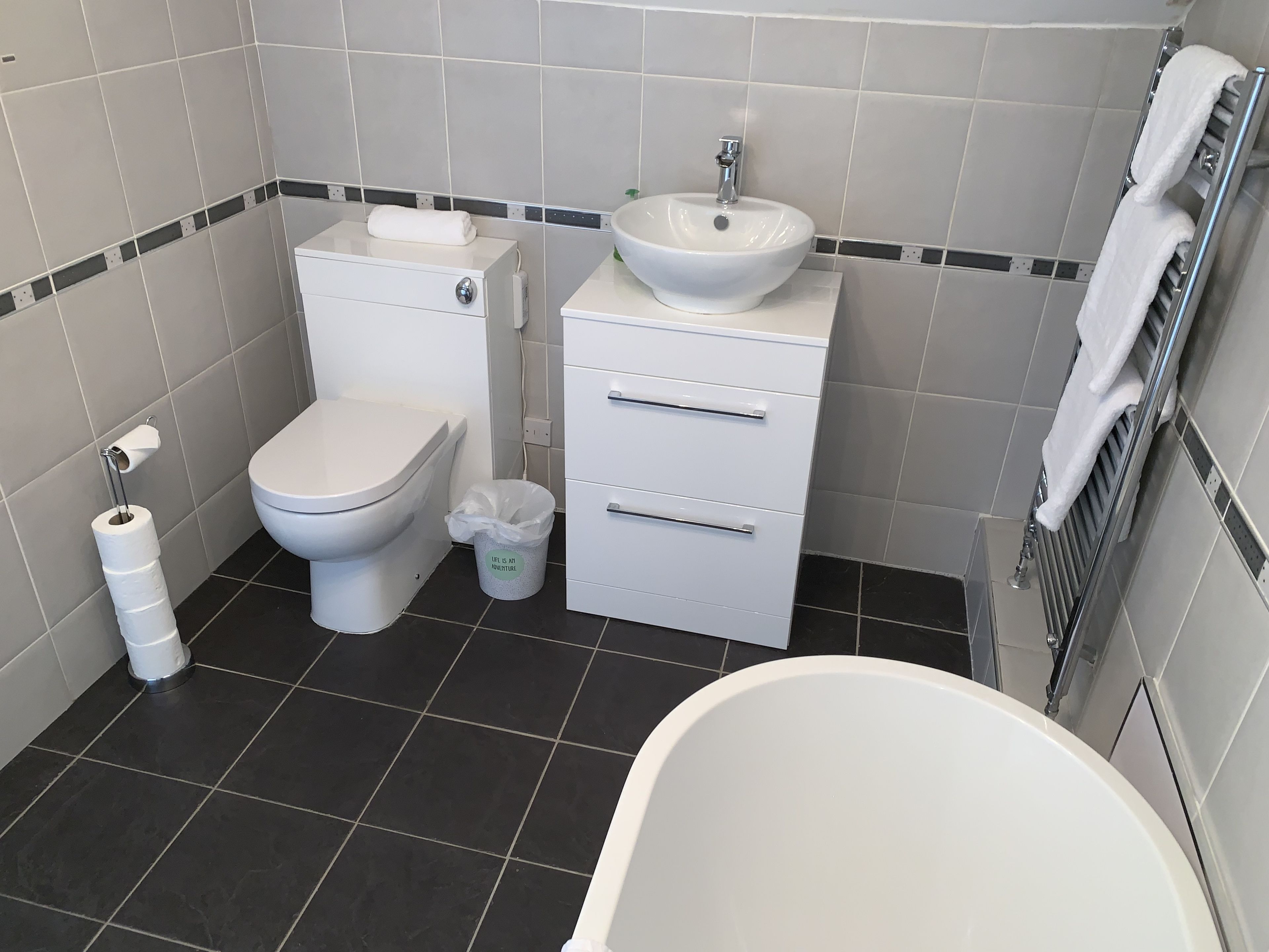 A bathroom with a toilet, bidet, sink, and bathtub.