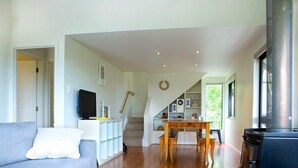 Een moderne woonkamer met een bank, een salontafel, een open haard en een trap naar een vide.