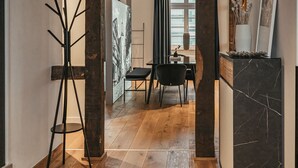 Ein modernes Interieur mit Holzboden, einer Essecke mit Tisch und Stühlen sowie einem Garderobenschrank.