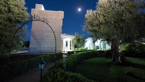 Un edificio con un cancello d'ingresso imponente, un prato curato e un cielo notturno sereno.