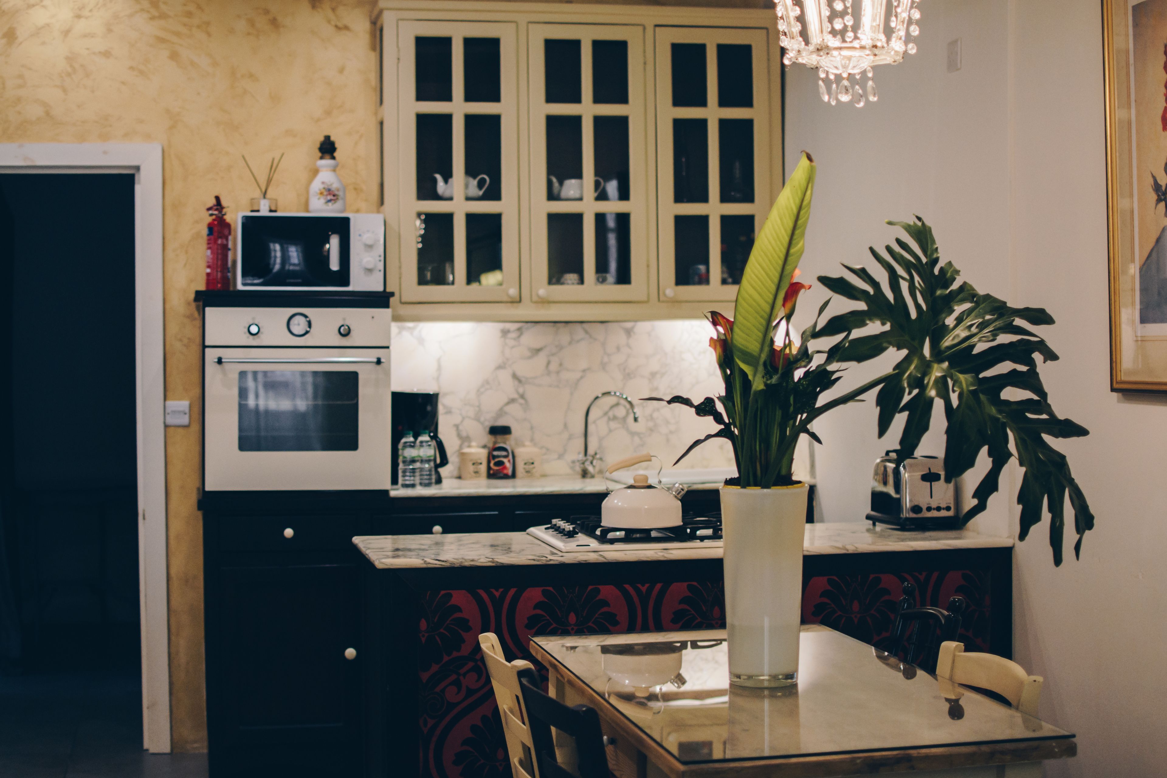 A kitchen with a marble countertop, a dining table, and a potted plant.