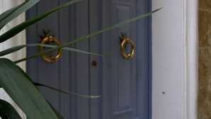Une porte bleue ornée de deux anneaux dorés.