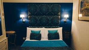 Une chambre à coucher avec un grand lit, deux lampes fixées au mur et une tête de lit à motifs.