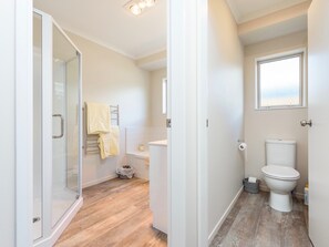 A modern bathroom with a glass shower enclosure, a toilet, and a sink.